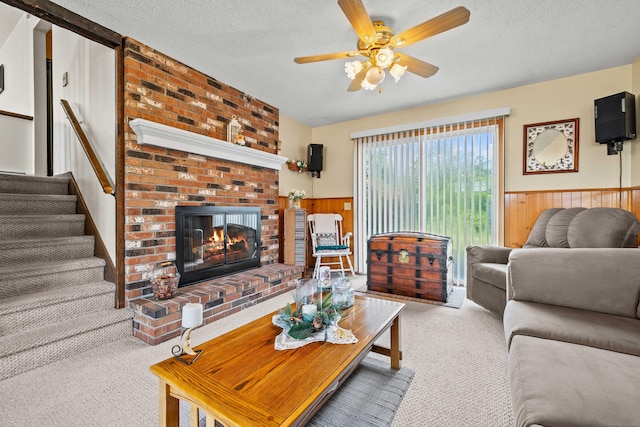 2 Marion Ln, Canterbury, CT 06331 - living area featuring carpet flooring, a textured ceiling, a brick fireplace, a wainscoted wall, and ceiling fan
