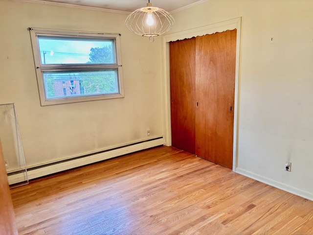 56 Clapboard Ridge Rd, Danbury, CT 06811 - unfurnished bedroom featuring a baseboard heating unit, crown molding, wood finished floors, a closet, and baseboards