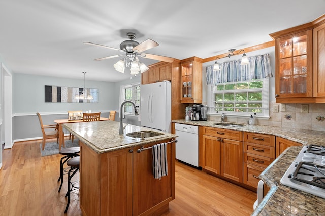 183 Brentmoor Rd, East Hartford, CT 06118 - kitchen with white appliances, brown cabinets, light stone countertops, and light wood-type flooring