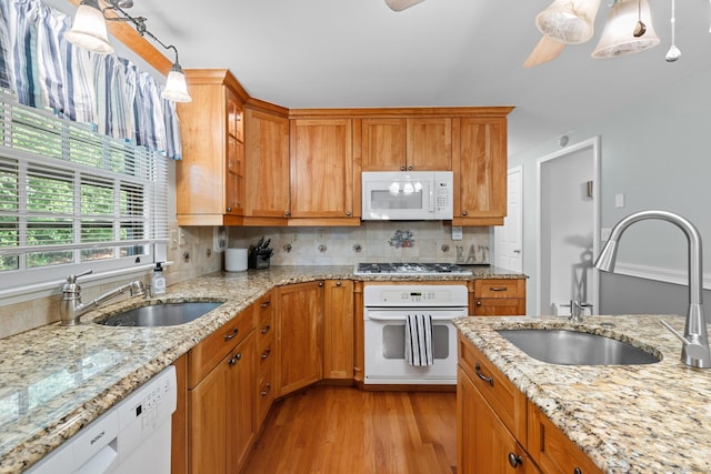 183 Brentmoor Rd, East Hartford, CT 06118 - kitchen with white appliances, light wood finished floors, backsplash, brown cabinetry, and light stone counters