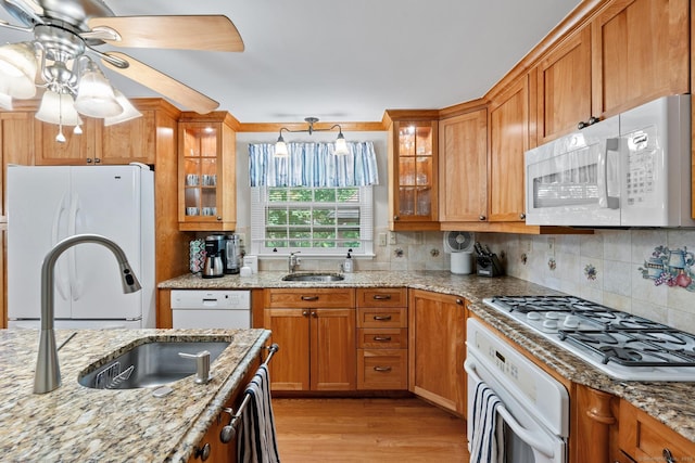 183 Brentmoor Rd, East Hartford, CT 06118 - kitchen featuring white appliances, light wood-style floors, ceiling fan, brown cabinetry, and tasteful backsplash
