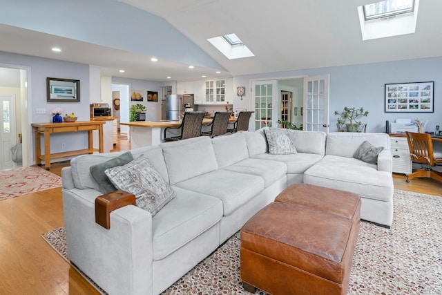19 Orchard Ln, New Canaan, CT 06840 - living room featuring a skylight, light wood finished floors, lofted ceiling, recessed lighting, and french doors
