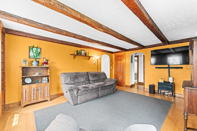 72 Westminster St, Hamden, CT 06518 - living area with arched walkways, a textured ceiling, wood finished floors, beam ceiling, and baseboards