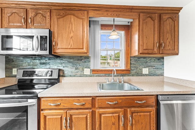 72 Westminster St, Hamden, CT 06518 - kitchen featuring appliances with stainless steel finishes, a sink, light countertops, brown cabinetry, and backsplash