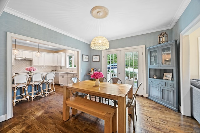 dining area featuring crown molding, wood finished floors, and french doors