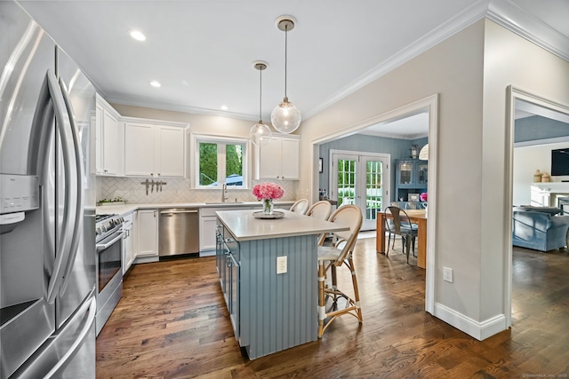 kitchen with appliances with stainless steel finishes, french doors, white cabinetry, crown molding, and decorative backsplash