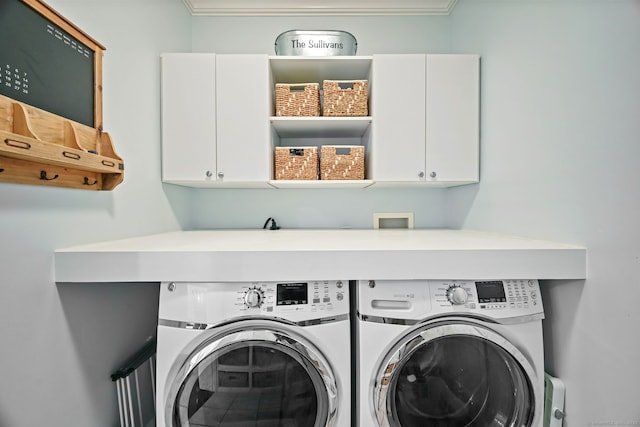 washroom featuring cabinet space, washing machine and clothes dryer, and crown molding