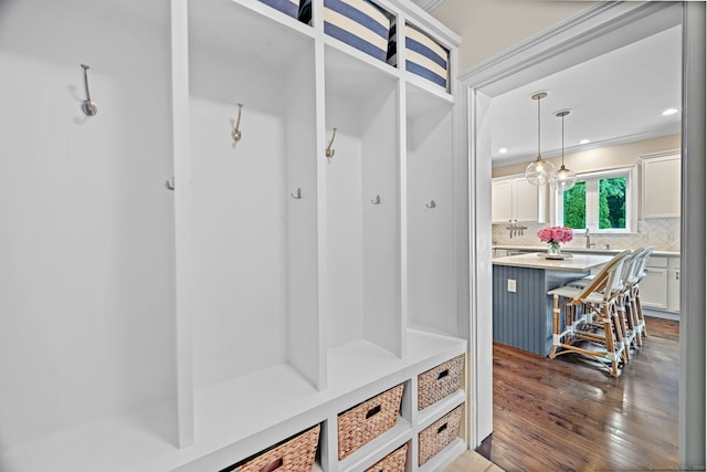 mudroom featuring dark wood-type flooring, recessed lighting, and a sink