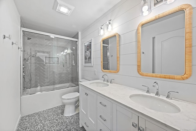 full bath with double vanity, toilet, enclosed tub / shower combo, and tile patterned flooring