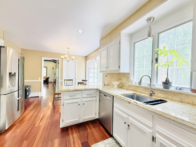 51 Boulder Brook Dr, Stamford, CT 06903 - kitchen with stainless steel appliances, a sink, a chandelier, a peninsula, and dark wood-style flooring