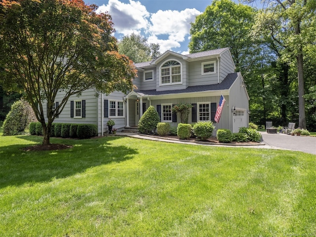 111 Washington Post Dr, Wilton, CT 06897 - traditional home with asphalt driveway, an attached garage, a front yard, a shingled roof, and board and batten siding