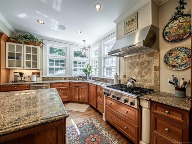 111 Washington Post Dr, Wilton, CT 06897 - kitchen with stainless steel appliances, crown molding, light wood finished floors, range hood, and brown cabinets