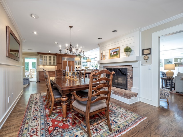 111 Washington Post Dr, Wilton, CT 06897 - dining room with crown molding, a brick fireplace, dark wood-type flooring, a chandelier, and wainscoting