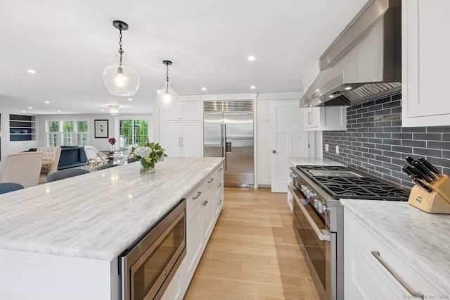 27 Waverly Rd, Darien, CT 06820 - kitchen with built in appliances, wall chimney range hood, white cabinets, recessed lighting, and light wood-style flooring