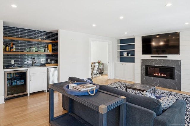 27 Waverly Rd, Darien, CT 06820 - living area featuring beverage cooler, wet bar, light wood finished floors, built in features, and recessed lighting