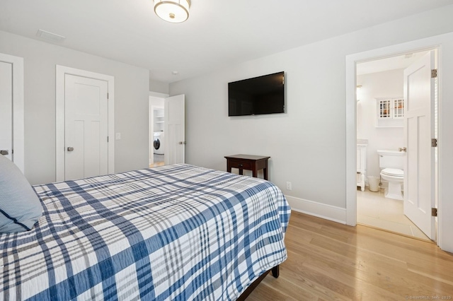 27 Waverly Rd, Darien, CT 06820 - bedroom with light wood-style floors, baseboards, washer / clothes dryer, and connected bathroom