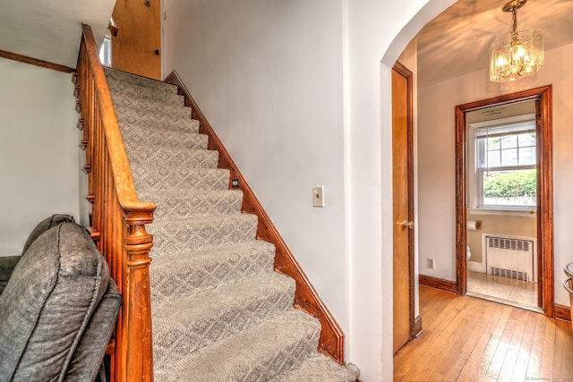 202 Mountain Rd, Cheshire, CT 06410 - stairway featuring radiator, arched walkways, hardwood / wood-style floors, and baseboards