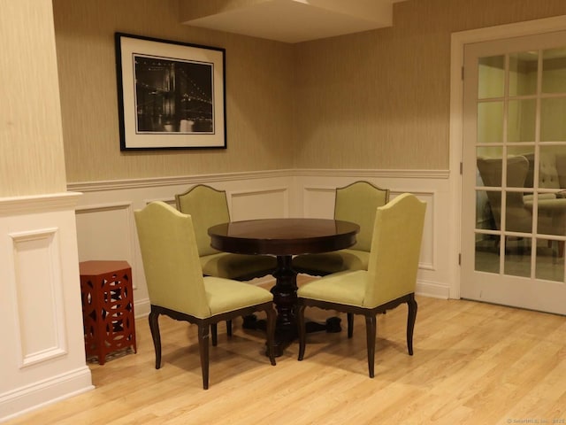 144 E Ave Apt B106, Norwalk, CT 06851 - dining area with a decorative wall, wood finished floors, and wainscoting
