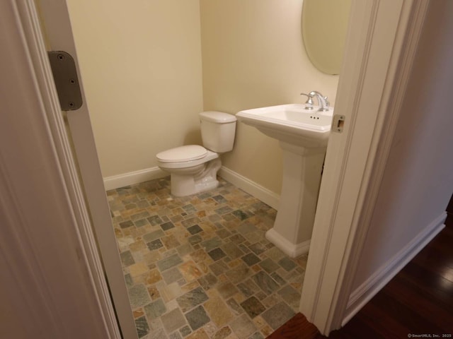 144 E Ave Apt B106, Norwalk, CT 06851 - bathroom with baseboards, toilet, and stone finish floors