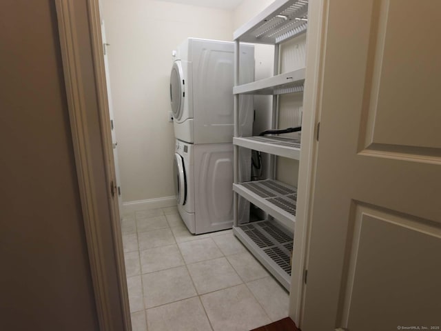 144 E Ave Apt B106, Norwalk, CT 06851 - laundry area with stacked washer / drying machine, light tile patterned flooring, and baseboards