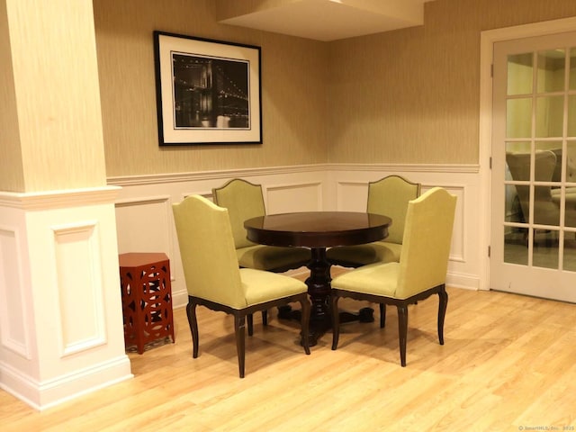 144 E Ave Apt B106, Norwalk, CT 06851 - dining space featuring a decorative wall, wood finished floors, and a wainscoted wall