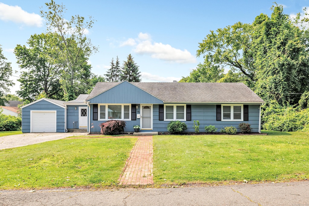 85 Elmsford Rd, Bridgeport, CT 06606 - view of front facade with driveway, an attached garage, a front yard, and roof with shingles