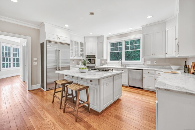 4 Lyons Plain Rd, Weston, CT 06883 - kitchen with appliances with stainless steel finishes, a breakfast bar, white cabinets, ornamental molding, and a center island