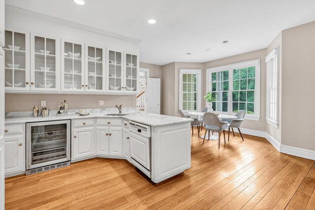 4 Lyons Plain Rd, Weston, CT 06883 - kitchen featuring wine cooler, dishwashing machine, a peninsula, white cabinets, and light wood-type flooring