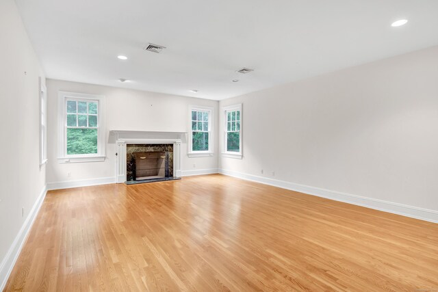 4 Lyons Plain Rd, Weston, CT 06883 - unfurnished living room featuring light wood-style flooring, healthy amount of natural light, a high end fireplace, and recessed lighting