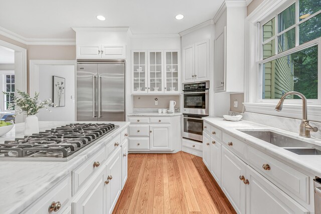 4 Lyons Plain Rd, Weston, CT 06883 - kitchen with stainless steel appliances, ornamental molding, light wood finished floors, glass insert cabinets, and recessed lighting