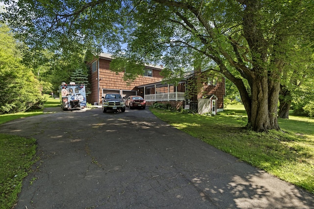 337 Woodbine Rd, Stamford, CT 06903 - view of side of home featuring asphalt driveway, a yard, and a garage