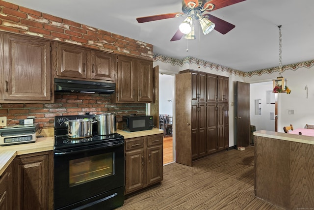 337 Woodbine Rd, Stamford, CT 06903 - kitchen featuring black appliances, under cabinet range hood, light countertops, and wood finished floors