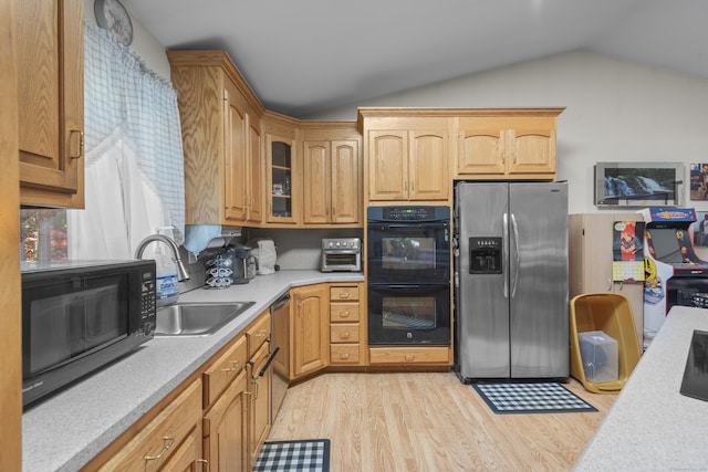 337 Woodbine Rd, Stamford, CT 06903 - kitchen with black appliances, a sink, vaulted ceiling, light countertops, and light wood-type flooring