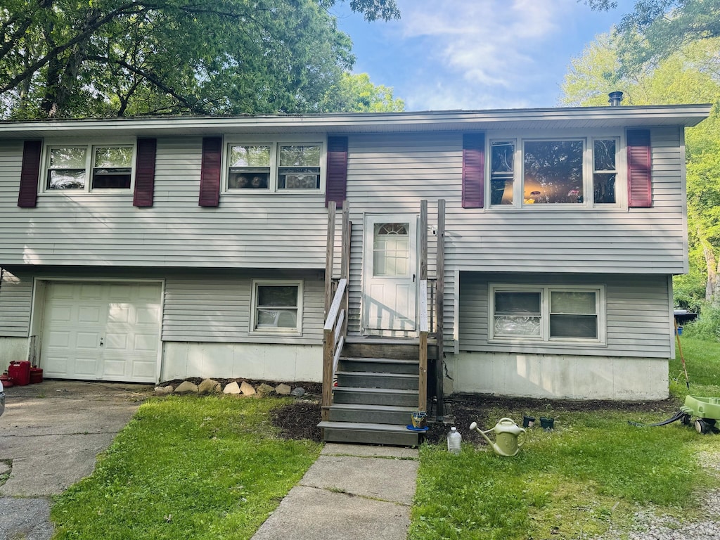 79 Black Hill Rd, Plainfield, CT 06374 - split foyer home with an attached garage, entry steps, driveway, and a front lawn