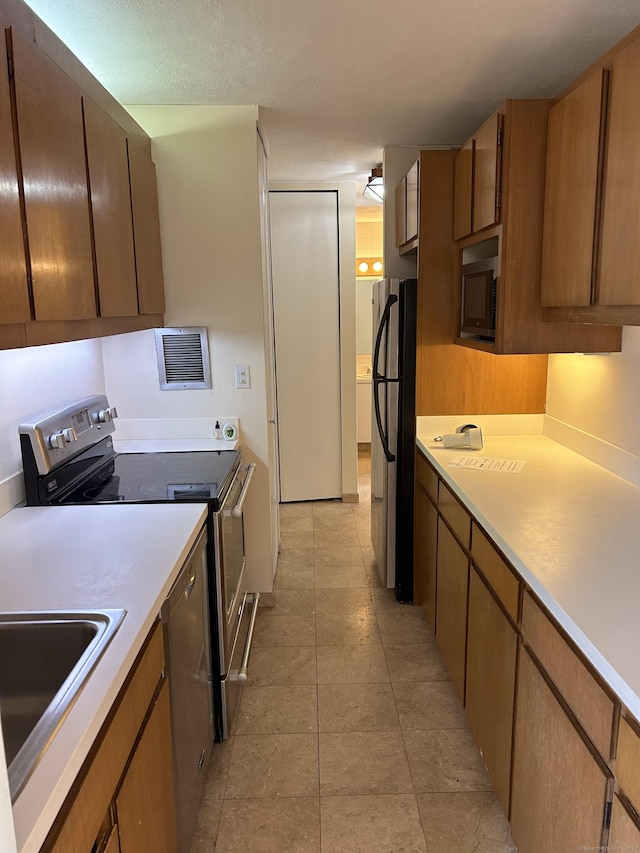 1 Gold St Apt 21G, Hartford, CT 06103 - kitchen featuring appliances with stainless steel finishes, light countertops, and brown cabinets