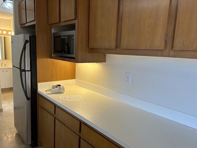 1 Gold St Apt 21G, Hartford, CT 06103 - kitchen with appliances with stainless steel finishes, light countertops, brown cabinetry, and a sink