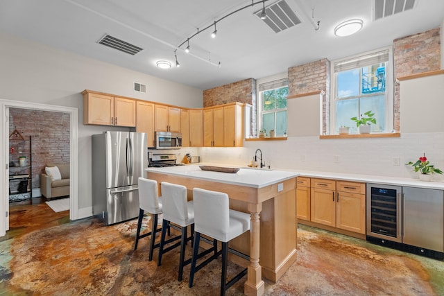 43 Chestnut St Unit 60, New Haven, CT 06511 - kitchen featuring appliances with stainless steel finishes, light brown cabinetry, beverage cooler, a center island, and light countertops