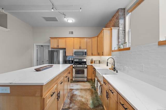 43 Chestnut St Unit 60, New Haven, CT 06511 - kitchen featuring appliances with stainless steel finishes, a sink, backsplash, light stone countertops, and a kitchen island