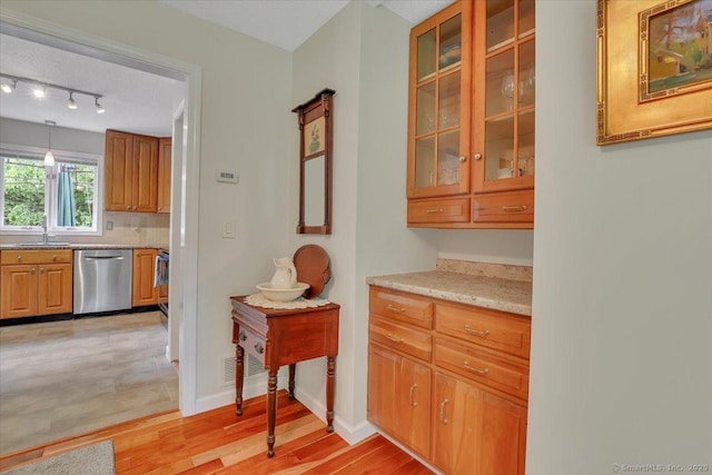 19 Oak Leaf Cir, Coventry, CT 06238 - bar area featuring stainless steel dishwasher, a sink, light wood-type flooring, rail lighting, and baseboards