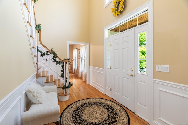 3 Autumn Ridge Rd, Newtown, CT 06470 - entryway featuring wainscoting, a decorative wall, light wood-type flooring, and stairway