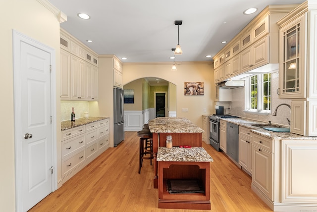 3 Autumn Ridge Rd, Newtown, CT 06470 - kitchen featuring a sink, stainless steel appliances, a center island, arched walkways, and wainscoting