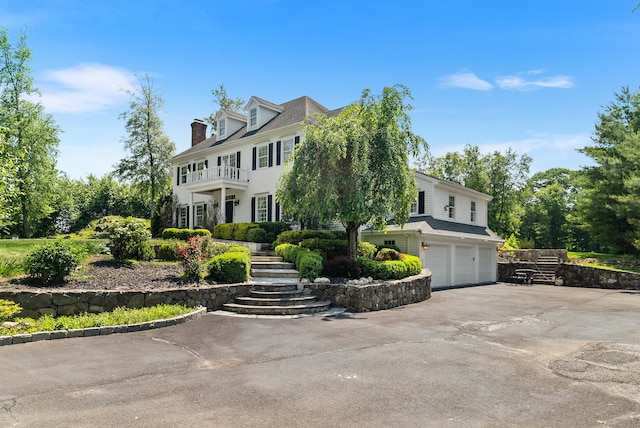 3 Autumn Ridge Rd, Newtown, CT 06470 - view of front facade featuring an attached garage, asphalt driveway, stairway, a balcony, and a chimney
