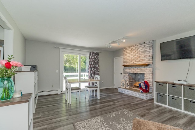 59 Valley Dr, Berlin, CT 06037 - living room with baseboard heating, wood finished floors, a brick fireplace, and rail lighting