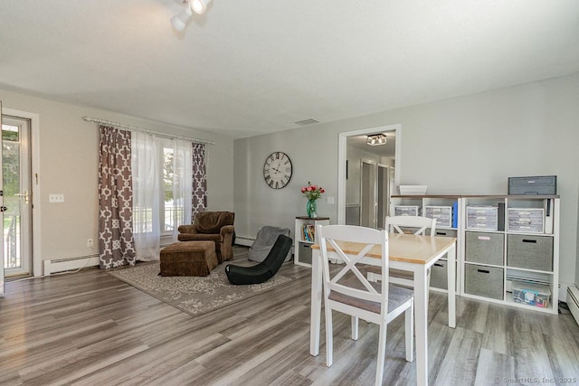 59 Valley Dr, Berlin, CT 06037 - dining area featuring a baseboard heating unit, wood finished floors, and plenty of natural light