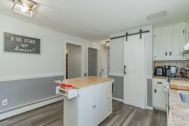 59 Valley Dr, Berlin, CT 06037 - kitchen featuring baseboard heating, dark wood-type flooring, white cabinetry, backsplash, and a barn door