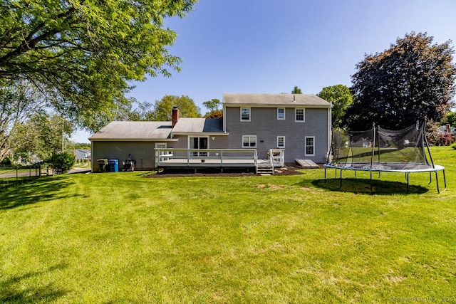 59 Valley Dr, Berlin, CT 06037 - rear view of house featuring a wooden deck, a lawn, a chimney, and a trampoline