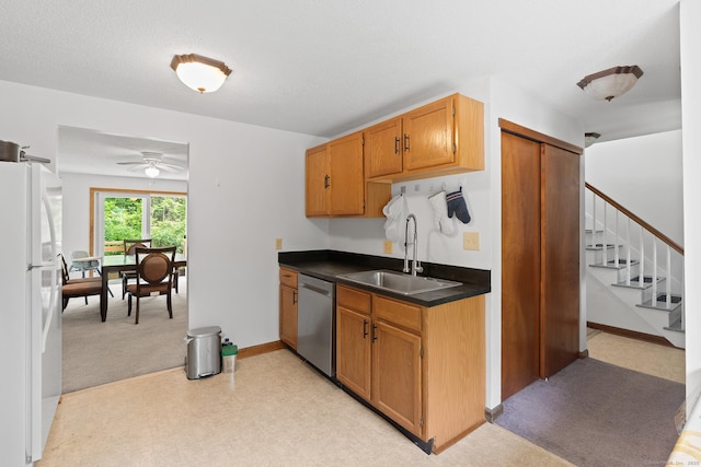 122 W Main St Apt E, Stafford, CT 06076 - kitchen with dishwasher, freestanding refrigerator, a sink, a ceiling fan, and dark countertops