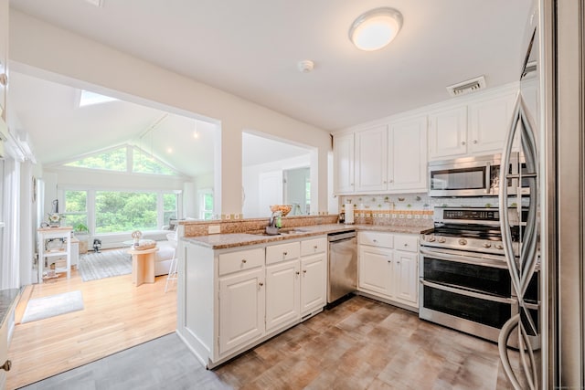 11 Walker Ln, Woodbridge, CT 06525 - kitchen with appliances with stainless steel finishes, light wood-style flooring, white cabinetry, and vaulted ceiling
