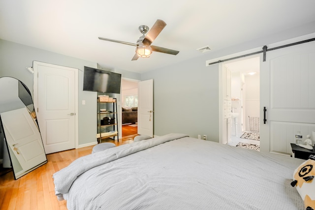 11 Walker Ln, Woodbridge, CT 06525 - bedroom featuring light wood-style floors, a barn door, ceiling fan, and connected bathroom