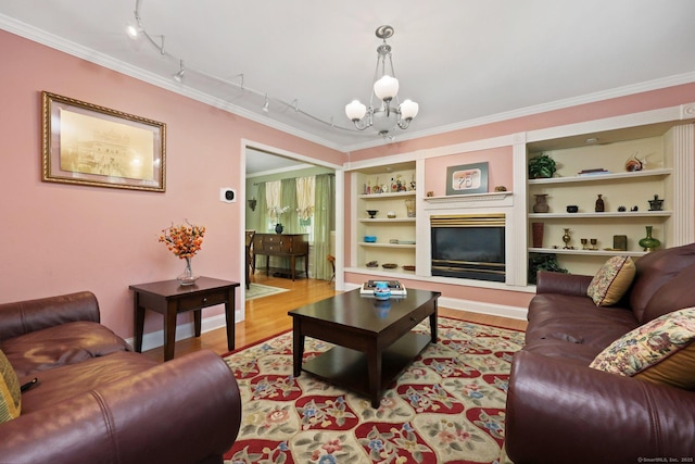 15 Oakledge Cir, Norwalk, CT 06854 - living area featuring rail lighting, a chandelier, light wood finished floors, ornamental molding, and a glass covered fireplace
